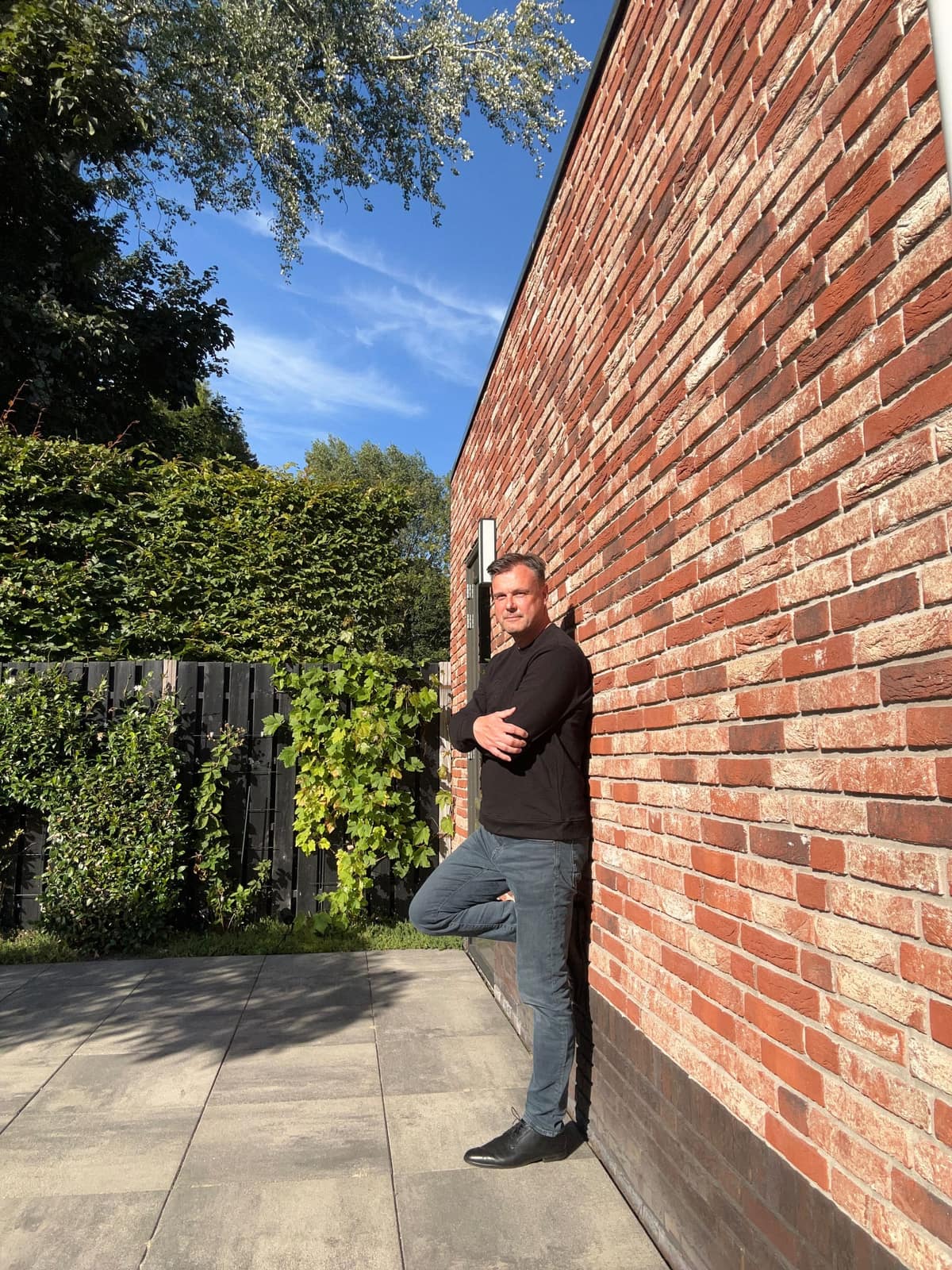 Vincent Bertram staand tegen een bakstenen muur