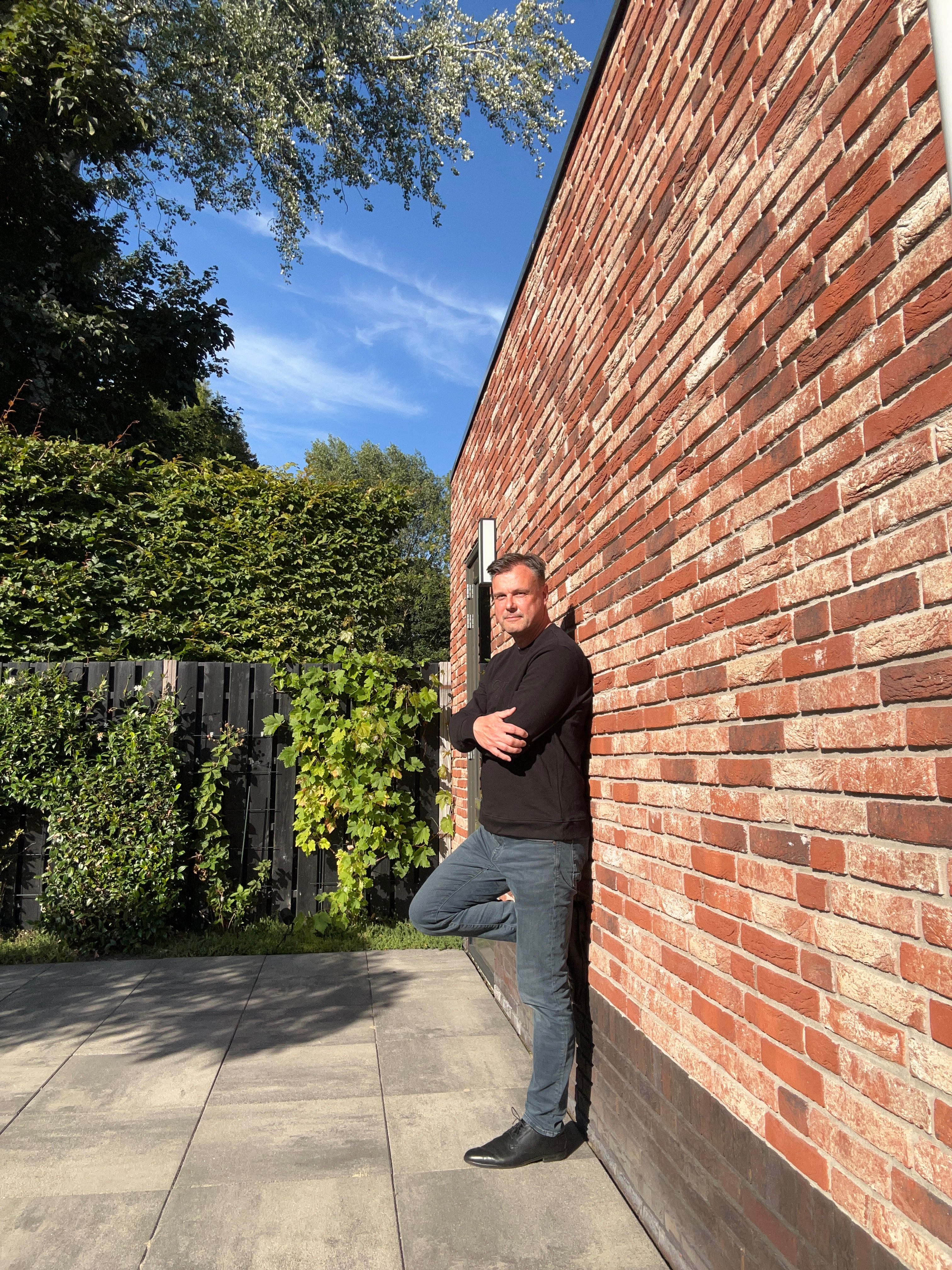 Vincent Bertram staand tegen een bakstenen muur
